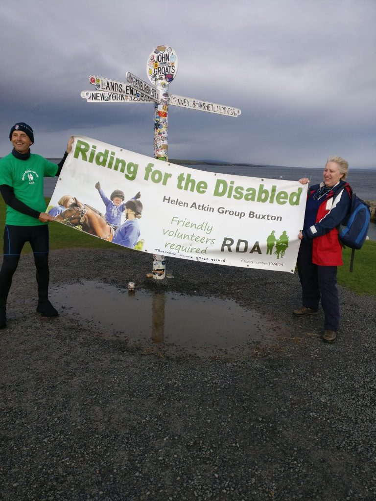 Two people holding a sponsored walk banner