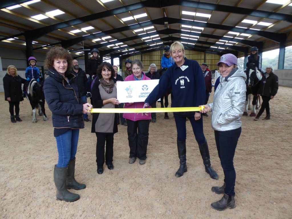 A group of people cutting a ribbon